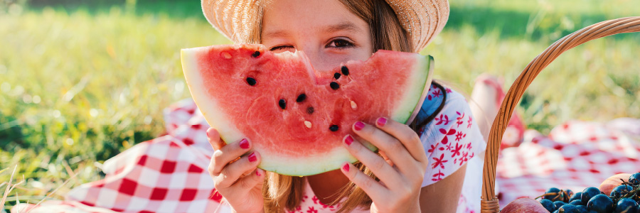 Image of a child holding a piece of watermelon