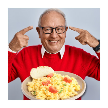 Image of a person pointing to their head and a plate full of eggs in front of them